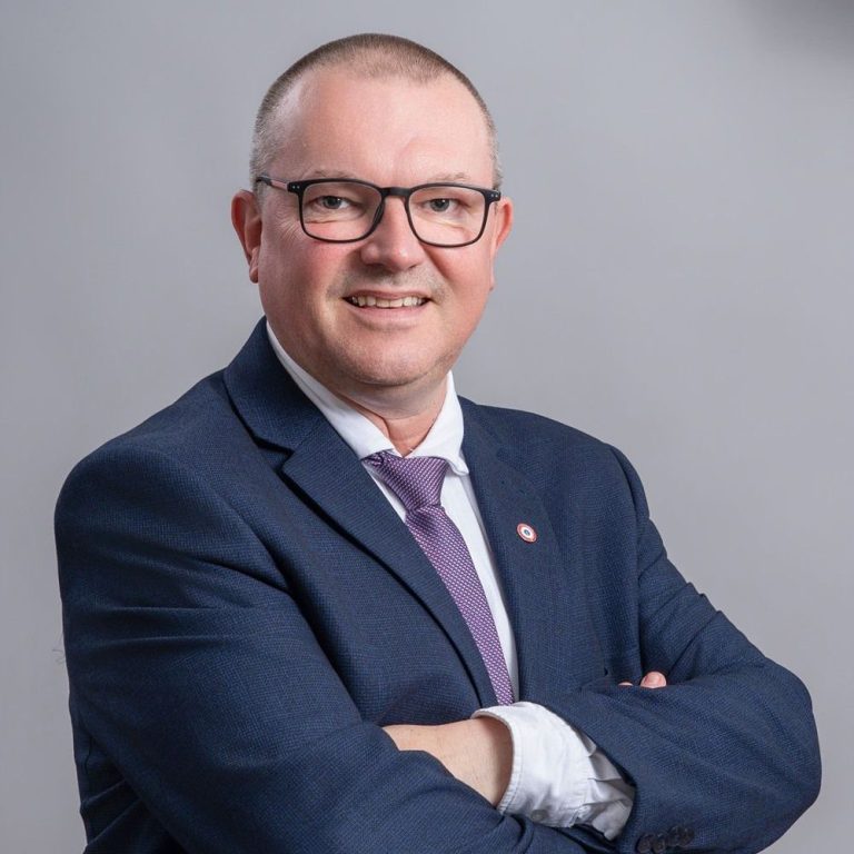 Portrait de Patrice Boyer, coach biblique, en costume avec les bras croisés